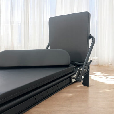 Side view of Queen Reformer with adjustable footbar and steel frame